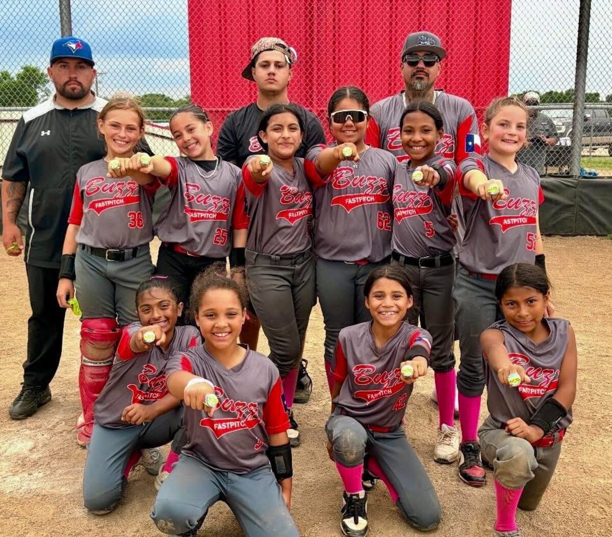 Youth fastpitch team posing with their medals